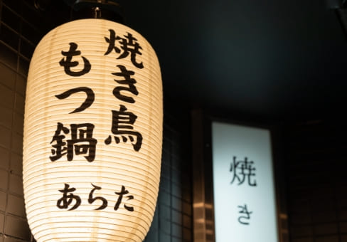 「焼き鳥 もつ鍋 あらた」と書かれた提灯